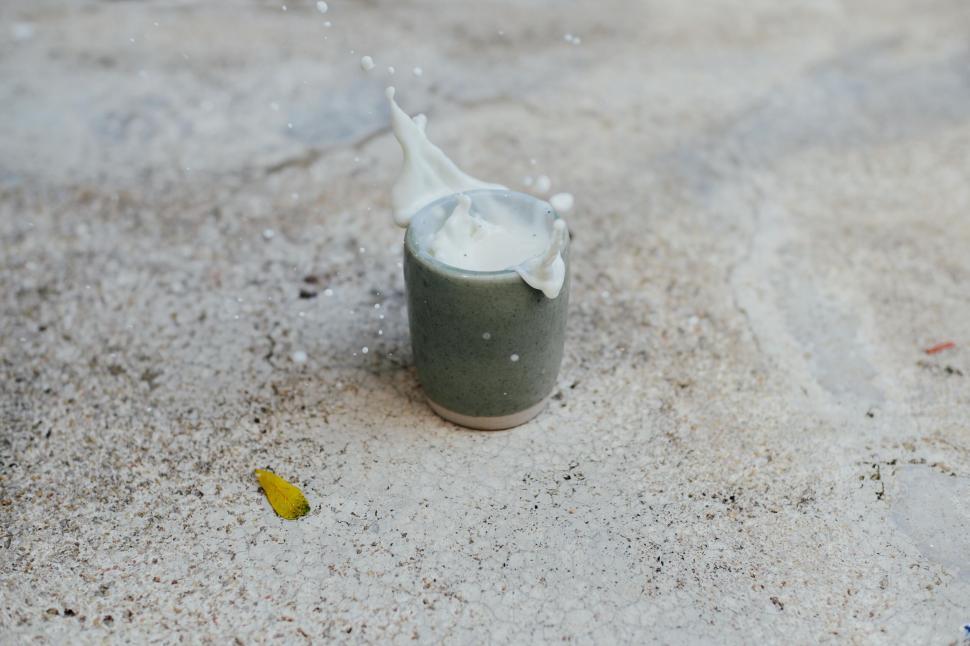 Free Image of A glass of milk splashing into a cup 