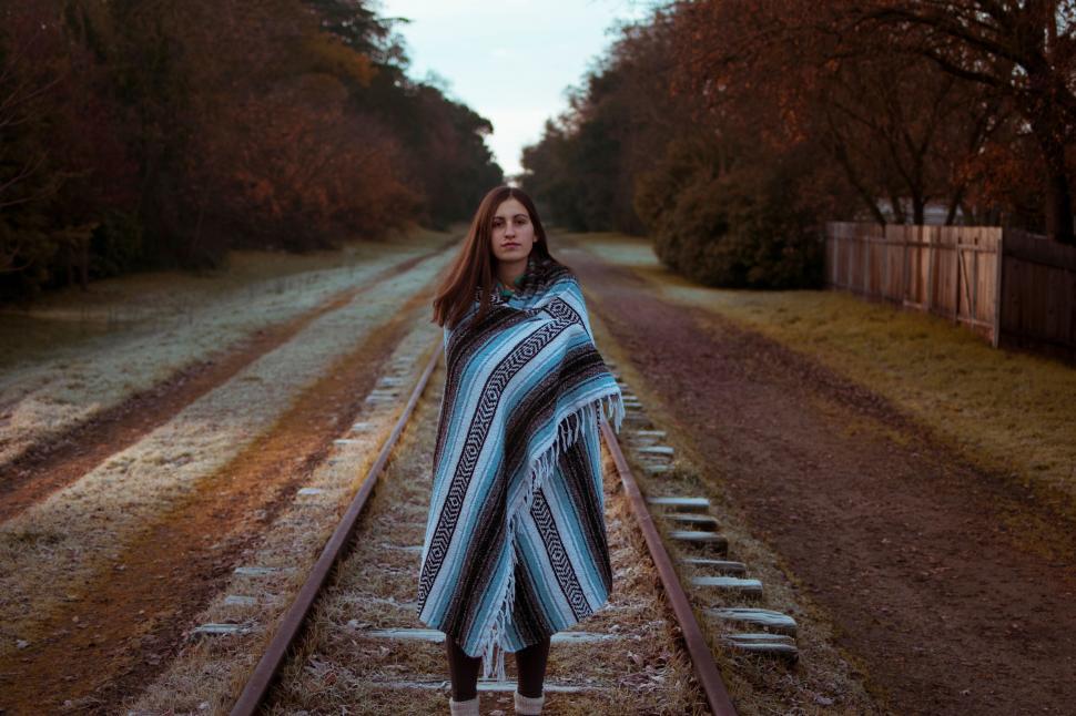 Free Image of A woman standing on train tracks 