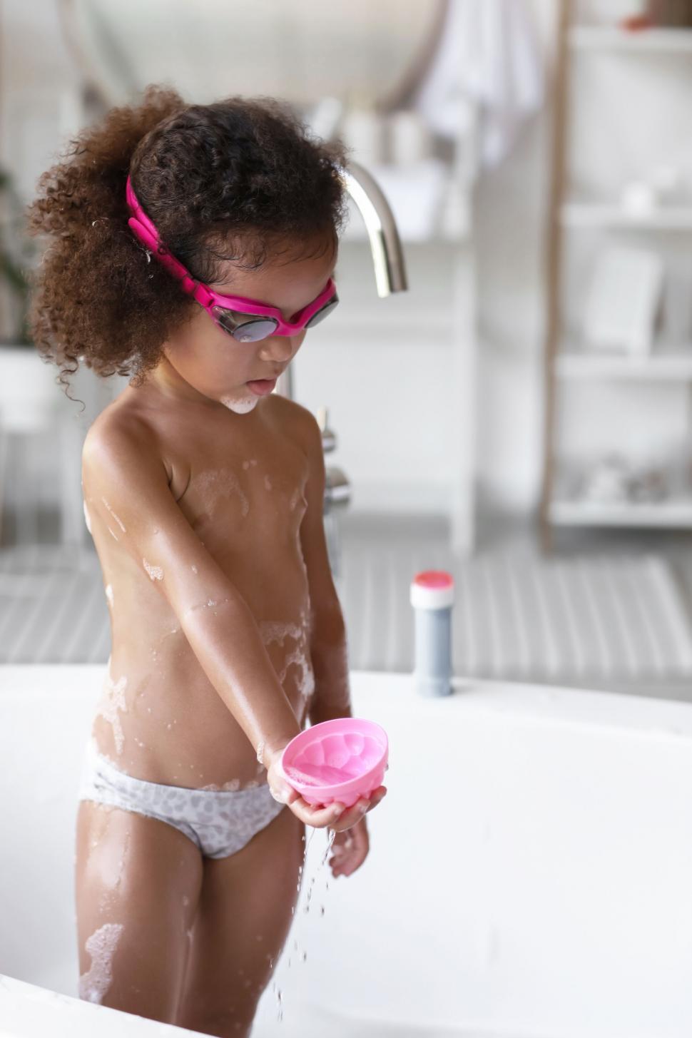 Free Image of Young girl playing with bubbles in bath 