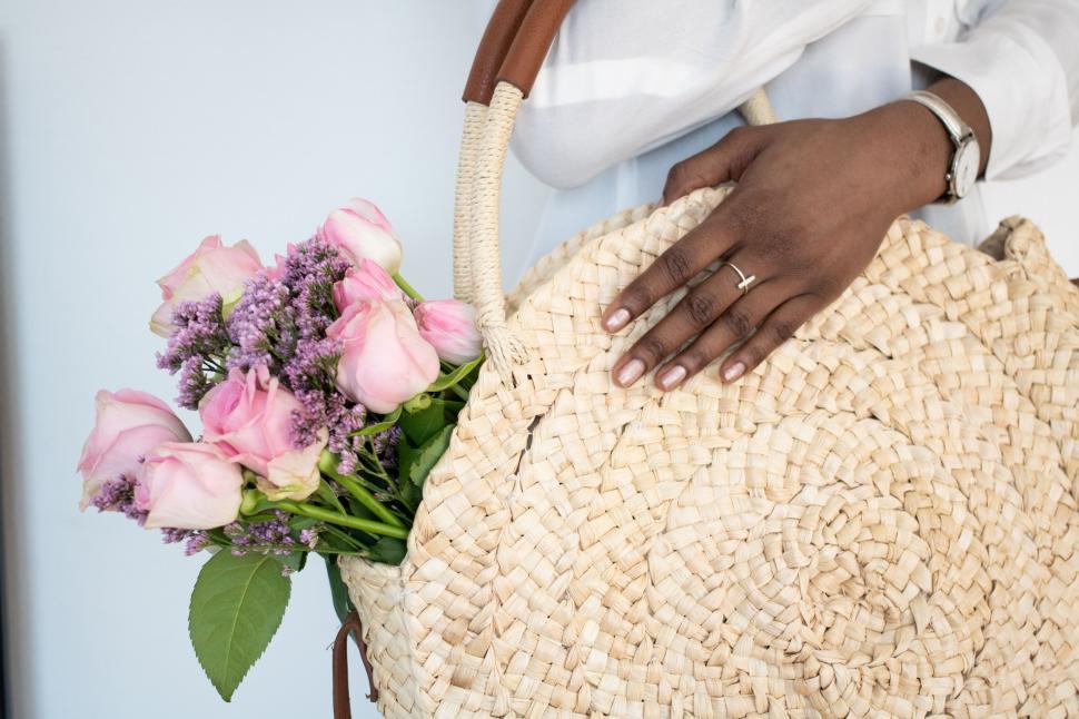 Free Image of Close-up of a woman holding a straw bag 