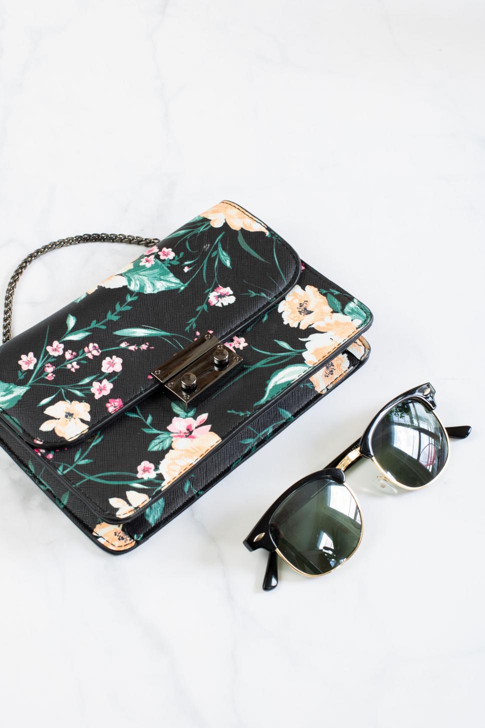 Free Image of Floral purse and sunglasses on marble 