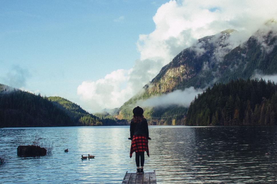 Free Image of Female silhouette by mountain lake at dawn 
