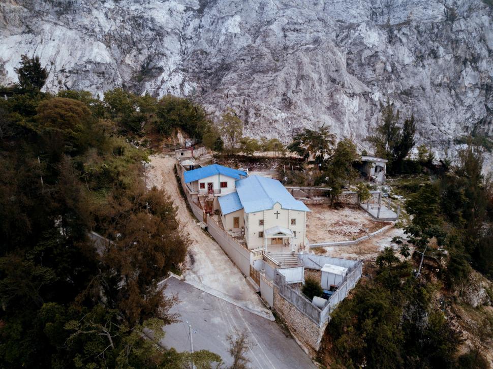 Free Image of Aerial view of a house near mountainous terrain 