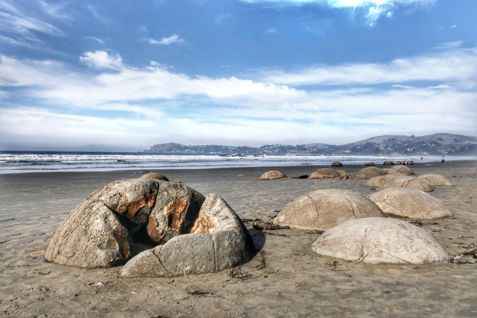 Free Image of Blue sky over boulder-strewn beach 