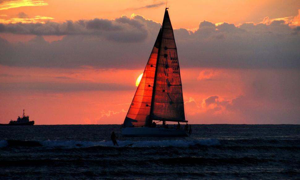 Free Image of Sailboat silhouette against sunset sky 