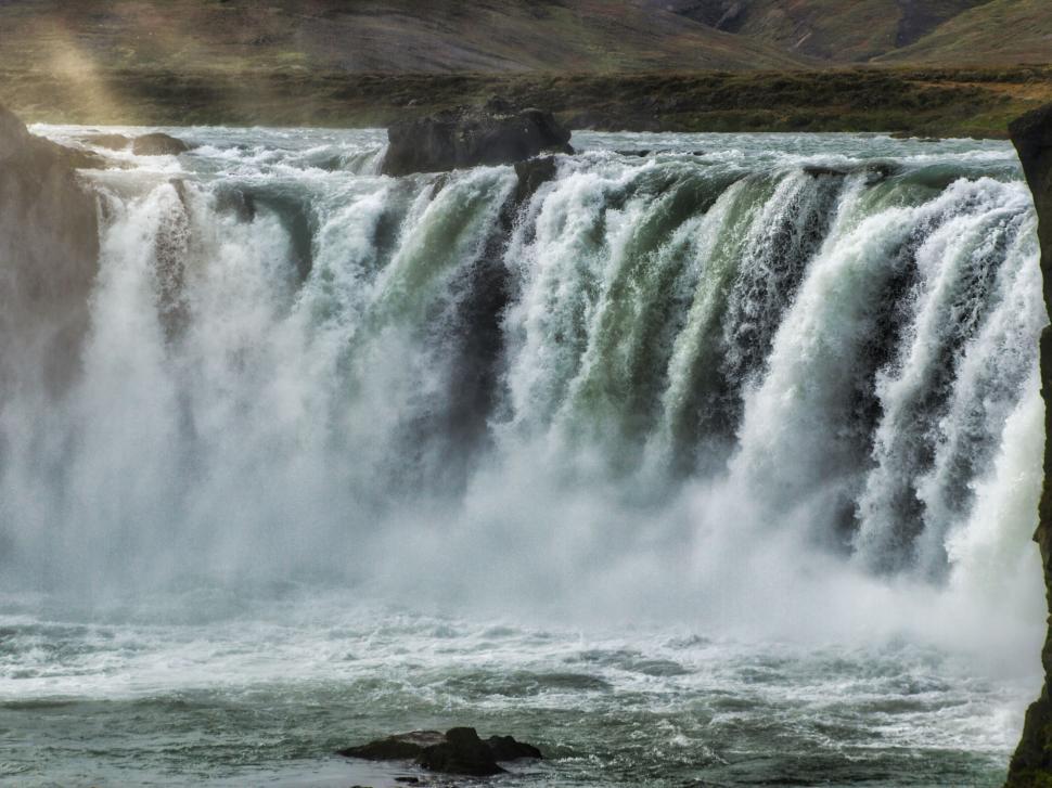 Free Image of Majestic waterfall in rugged landscape 