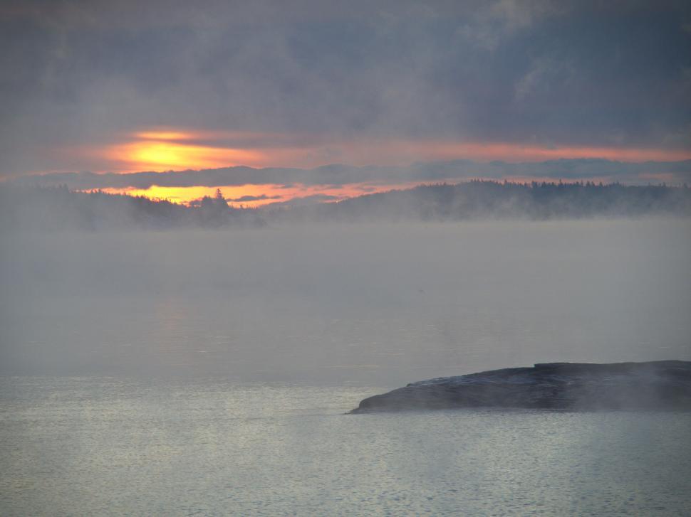 Free Image of Sunset over misty forest-covered lake 
