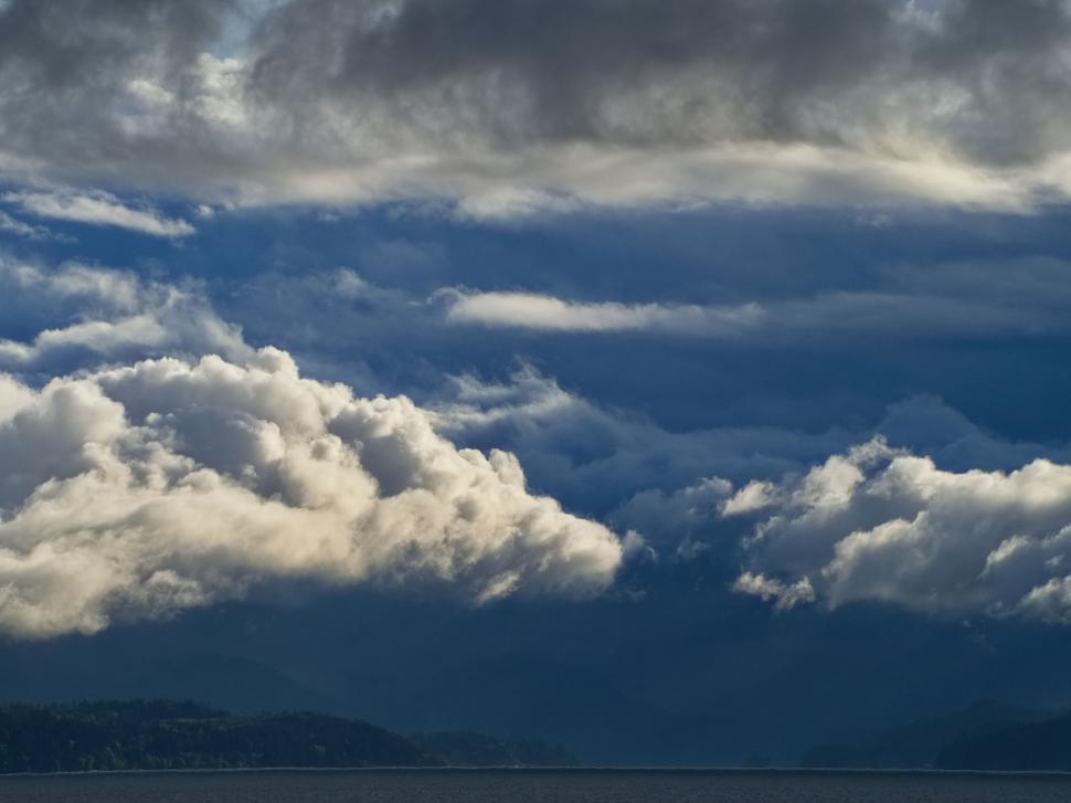 Free Image of Dramatic clouds over a mountainous landscape 