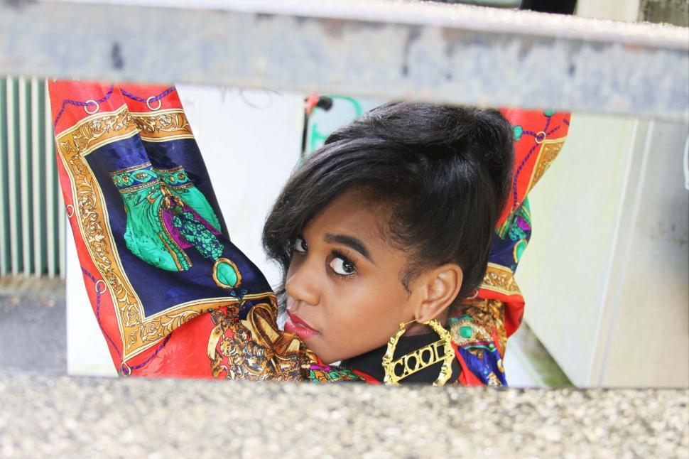 Free Image of Young woman peeking through colorful scarf 