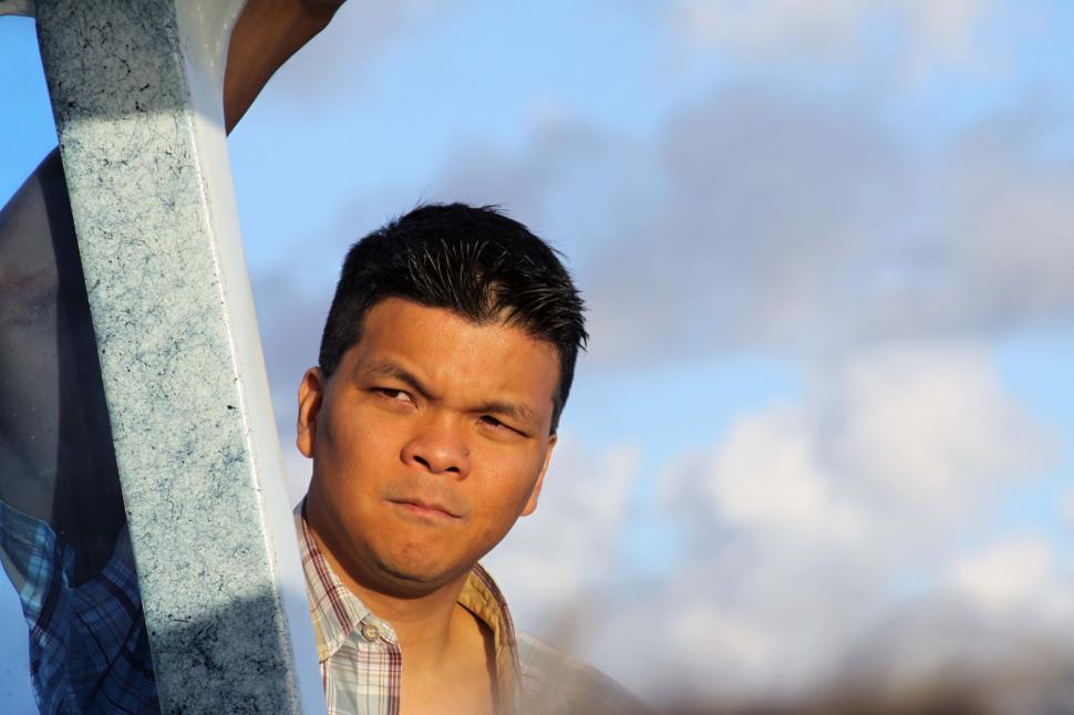 Free Image of Man peering around corner with intense gaze 