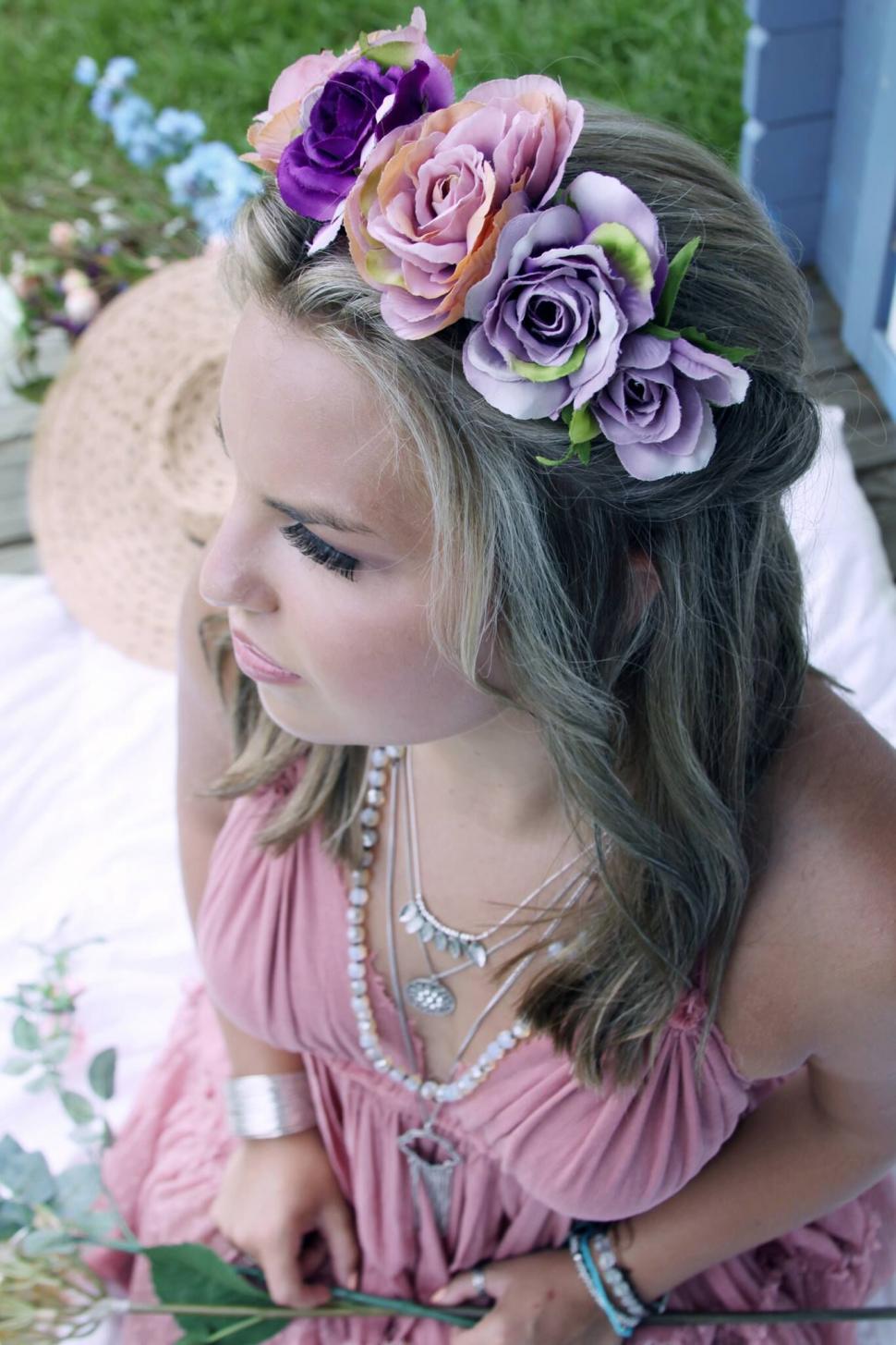 Free Image of Woman with floral crown sitting outdoors 