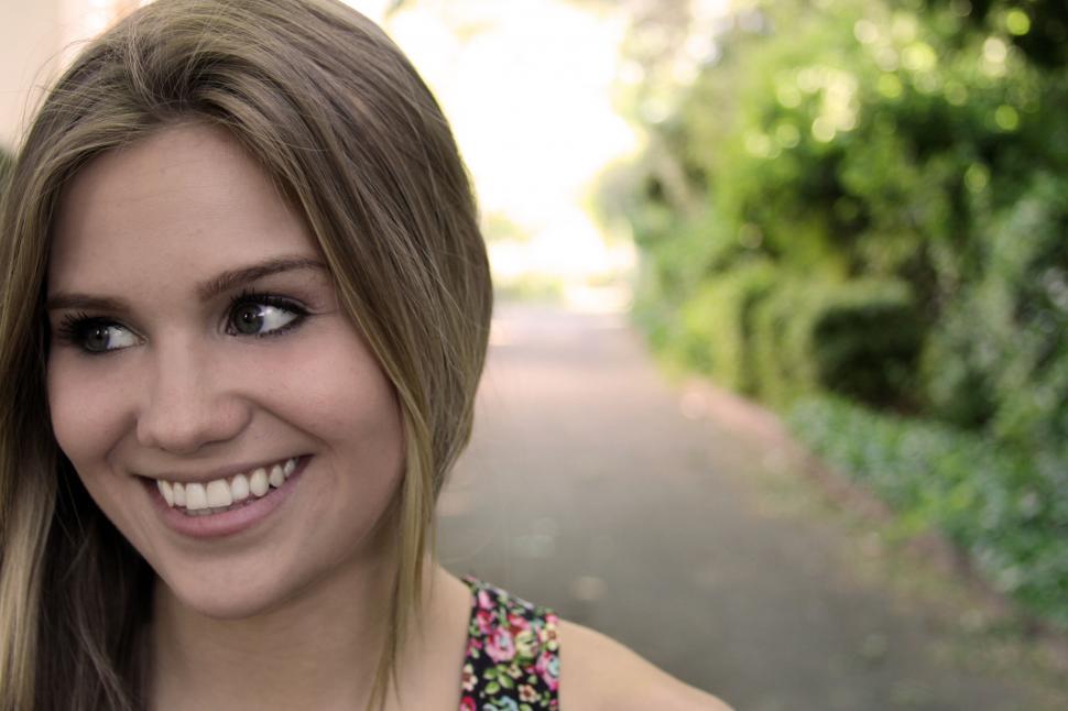 Free Image of Smiling young woman outdoors with bokeh 