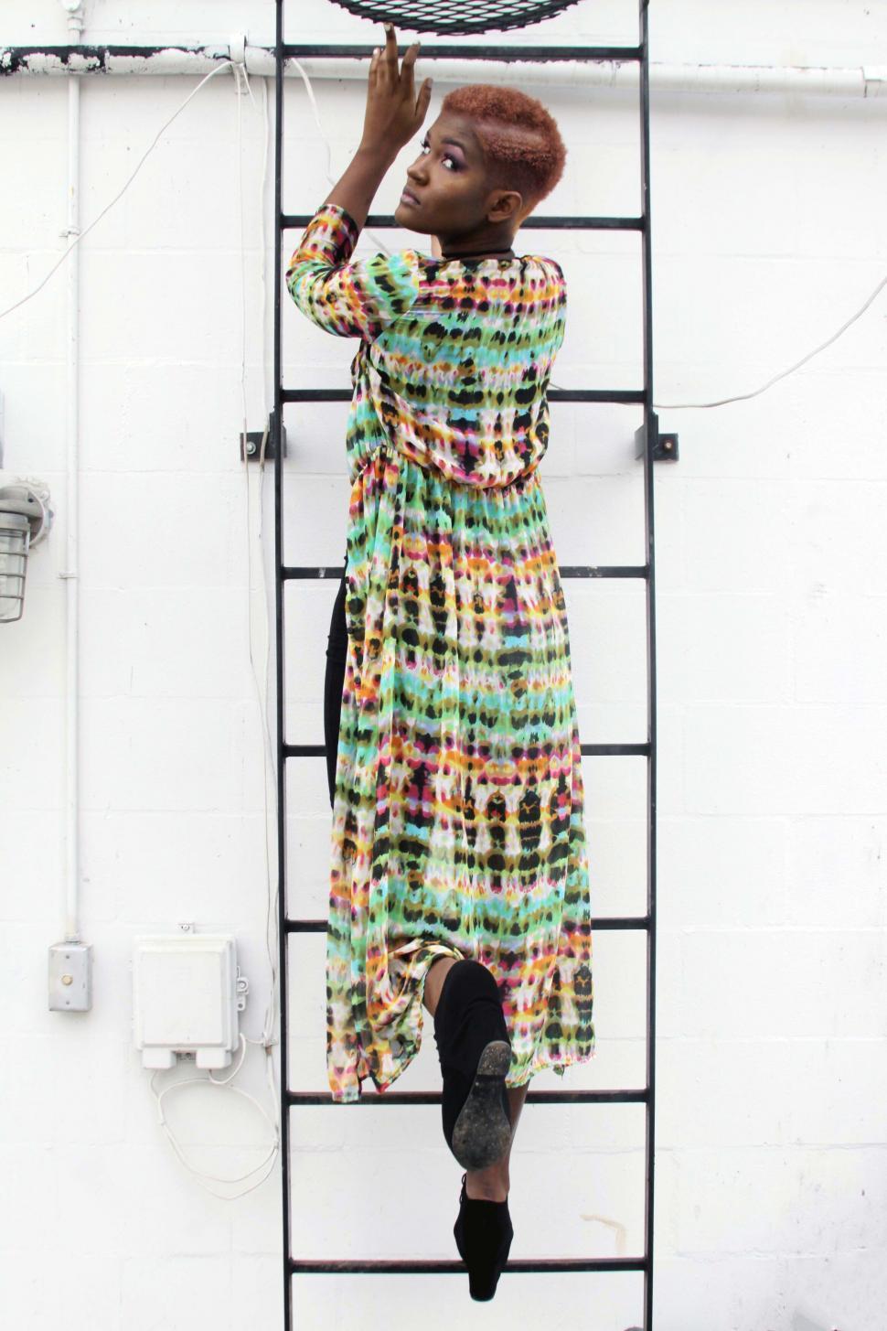 Free Image of Woman climbing an outdoor ladder 