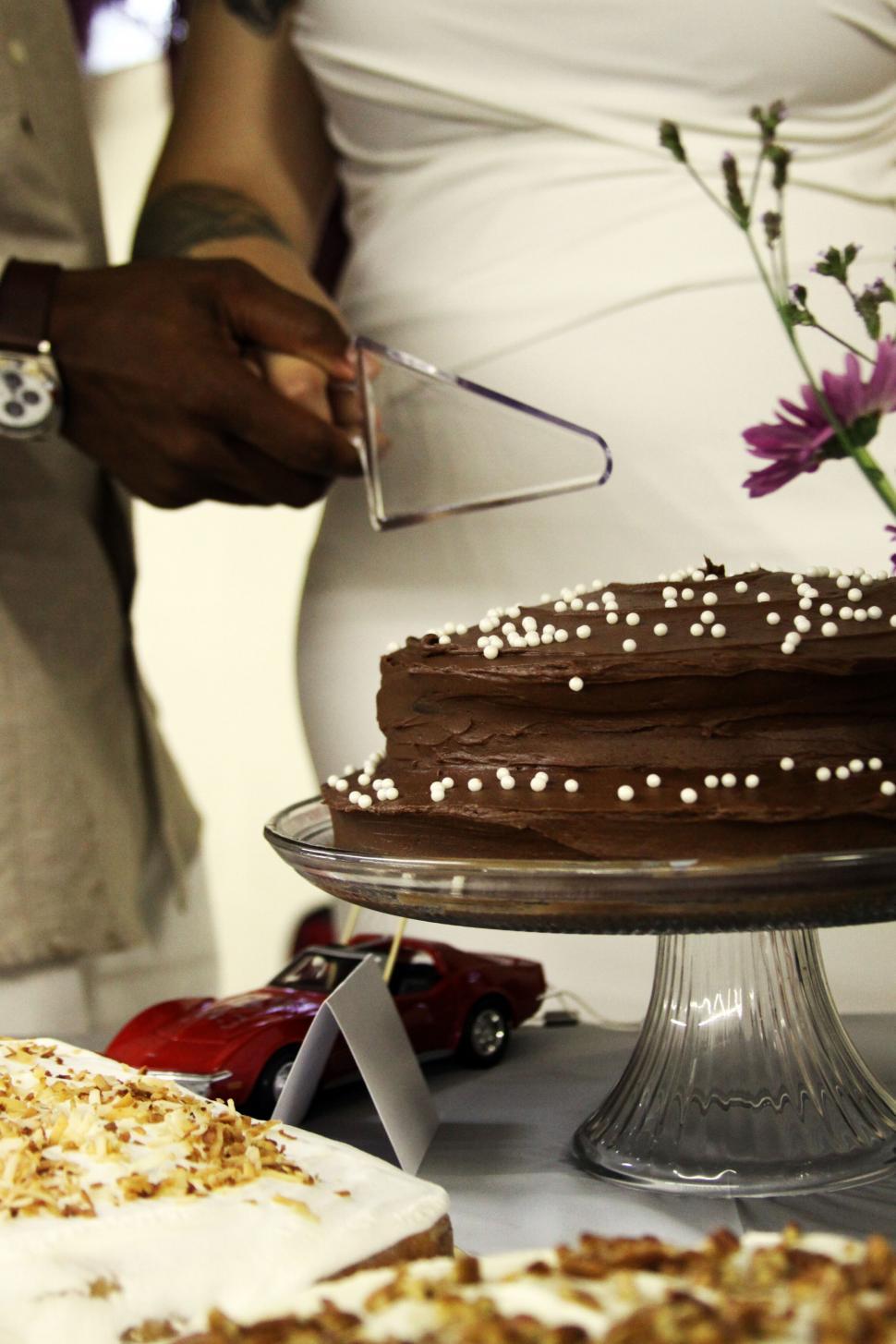 Free Image of Person slicing chocolate cake on table 