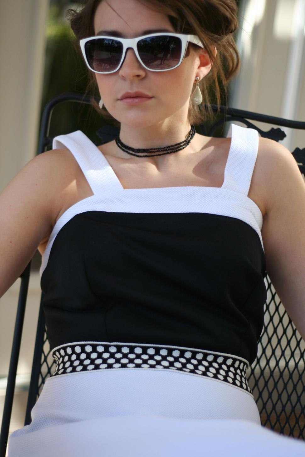 Free Image of Woman in sunglasses seated outdoors 