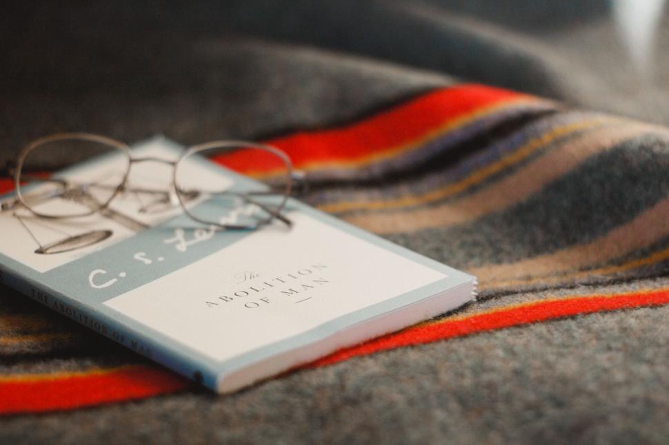 Free Image of Cozy reading setup with book and glasses 