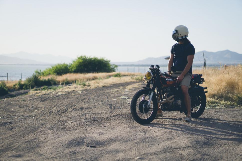 Free Image of Motorcyclist pausing on dirt road at sunset 