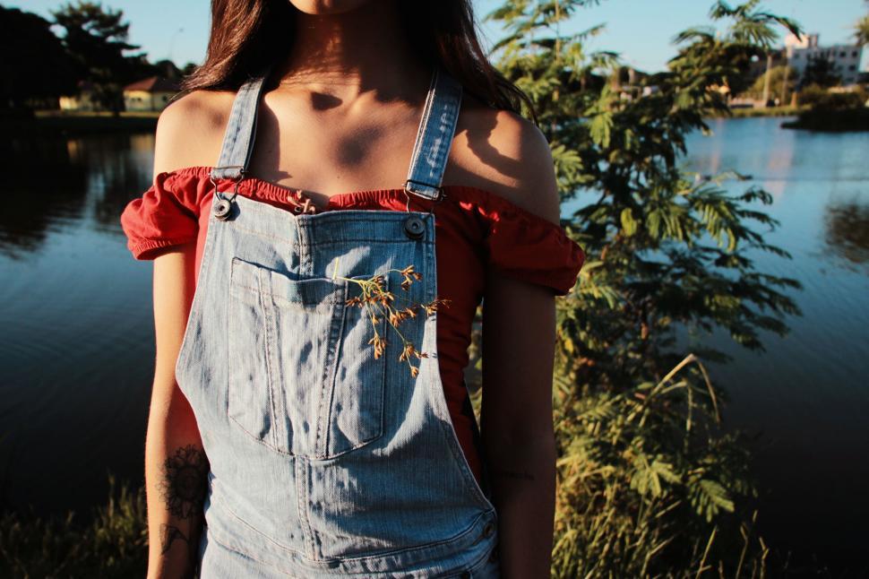 Free Image of Woman in denim overalls with twig in pocket 