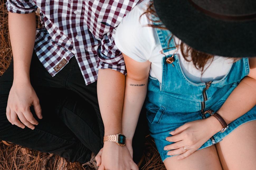Free Image of Couple sitting close together on the ground 