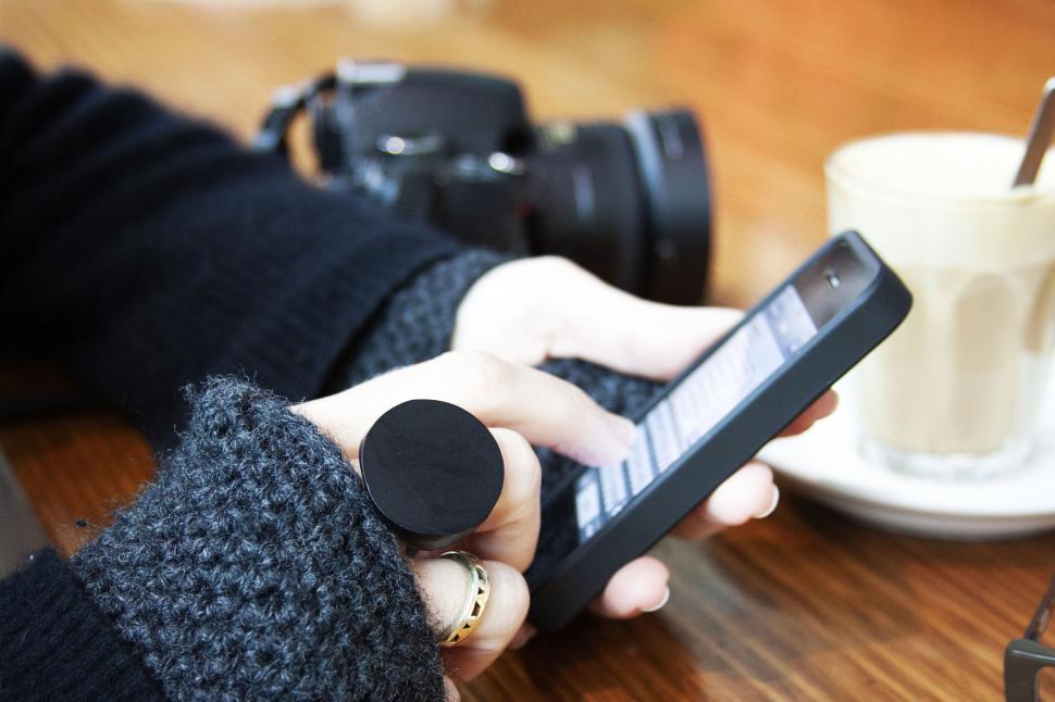 Free Image of Person using smartphone by coffee cup 