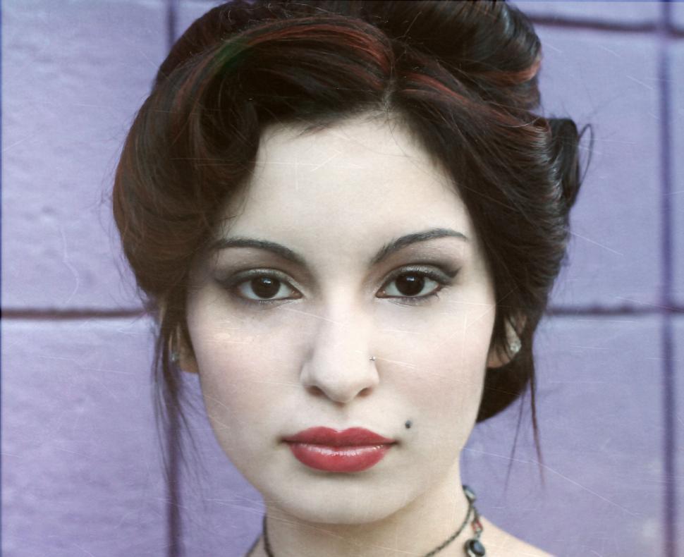Free Image of Young woman against violet wall 