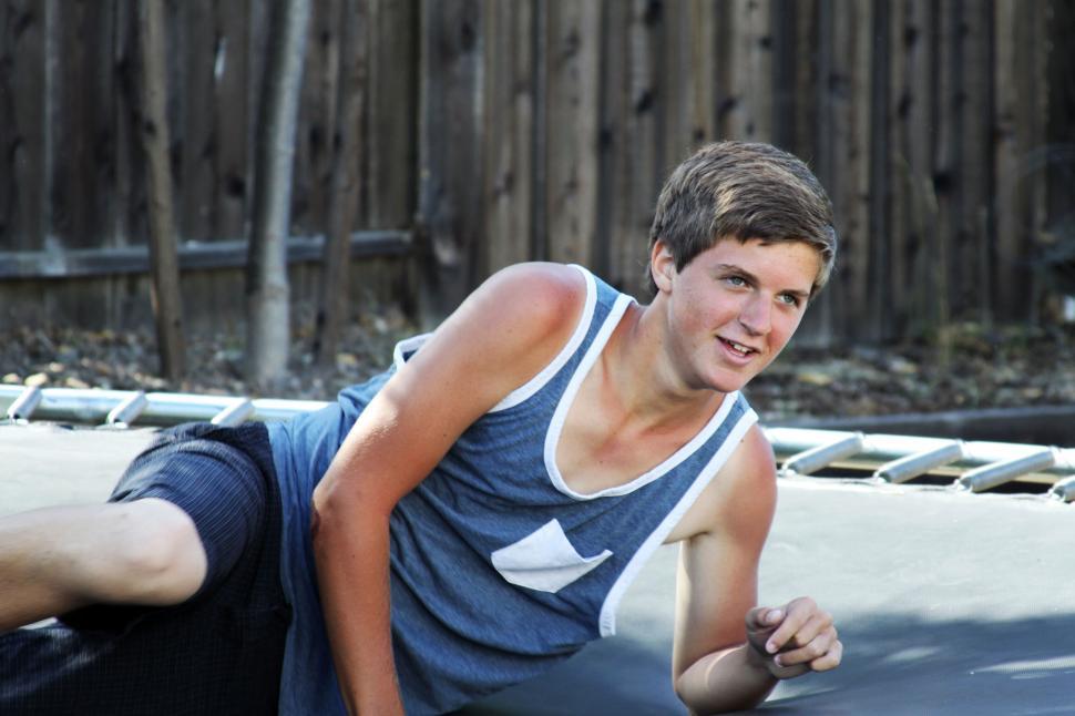 Free Image of Teenager relaxing on a trampoline 