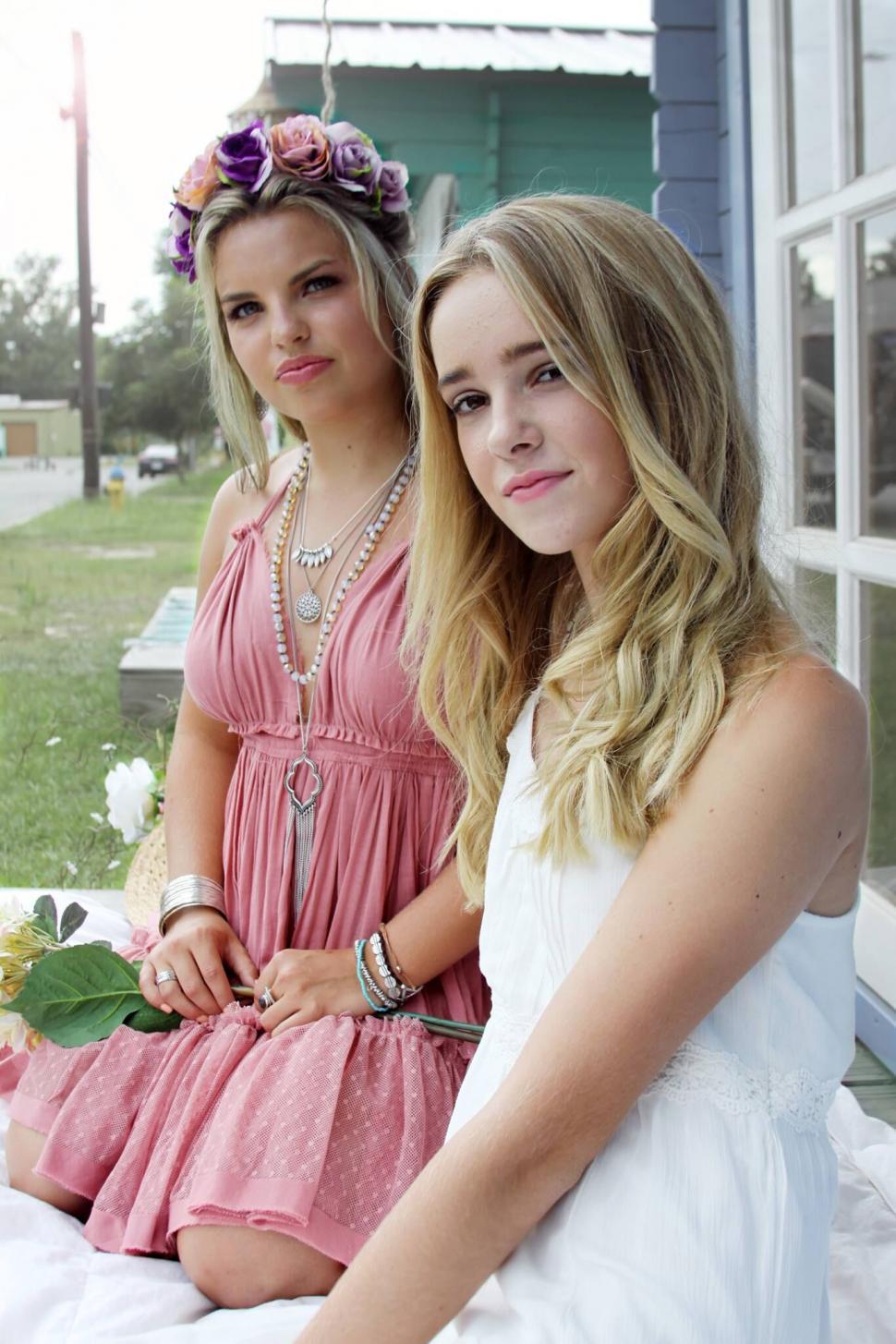 Free Image of Two girls with floral headwear in natural light 