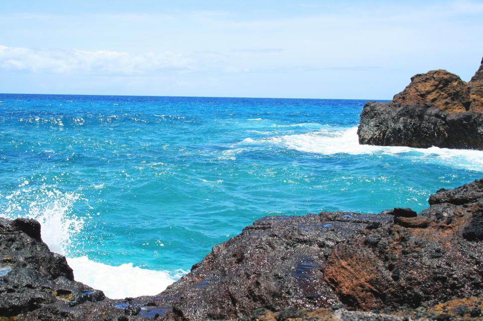 Free Image of Vibrant ocean waves crashing on rocky shore 