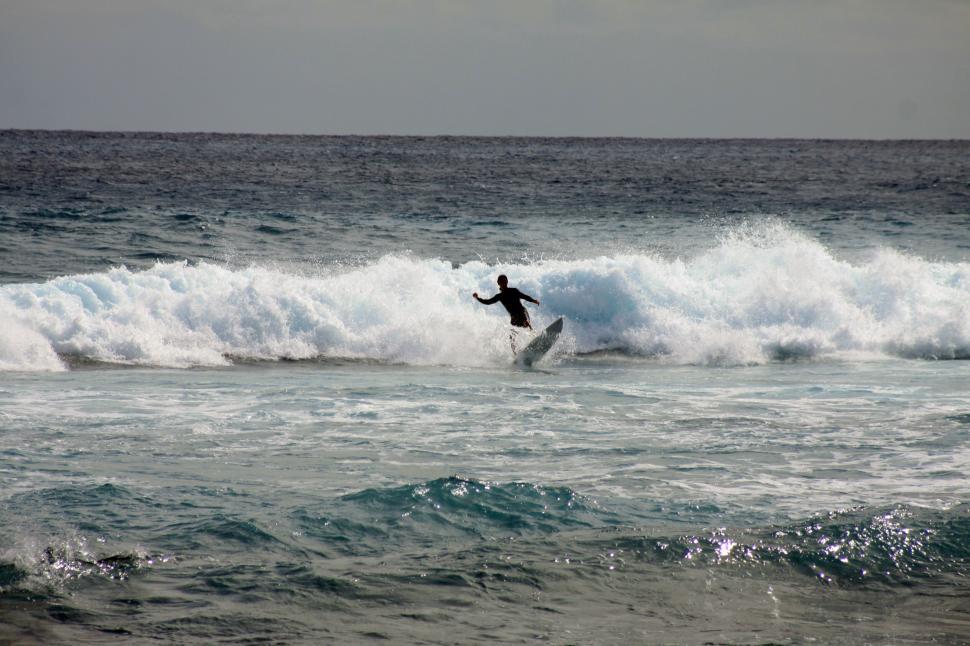 Free Image of Surfer riding a wave in the ocean 