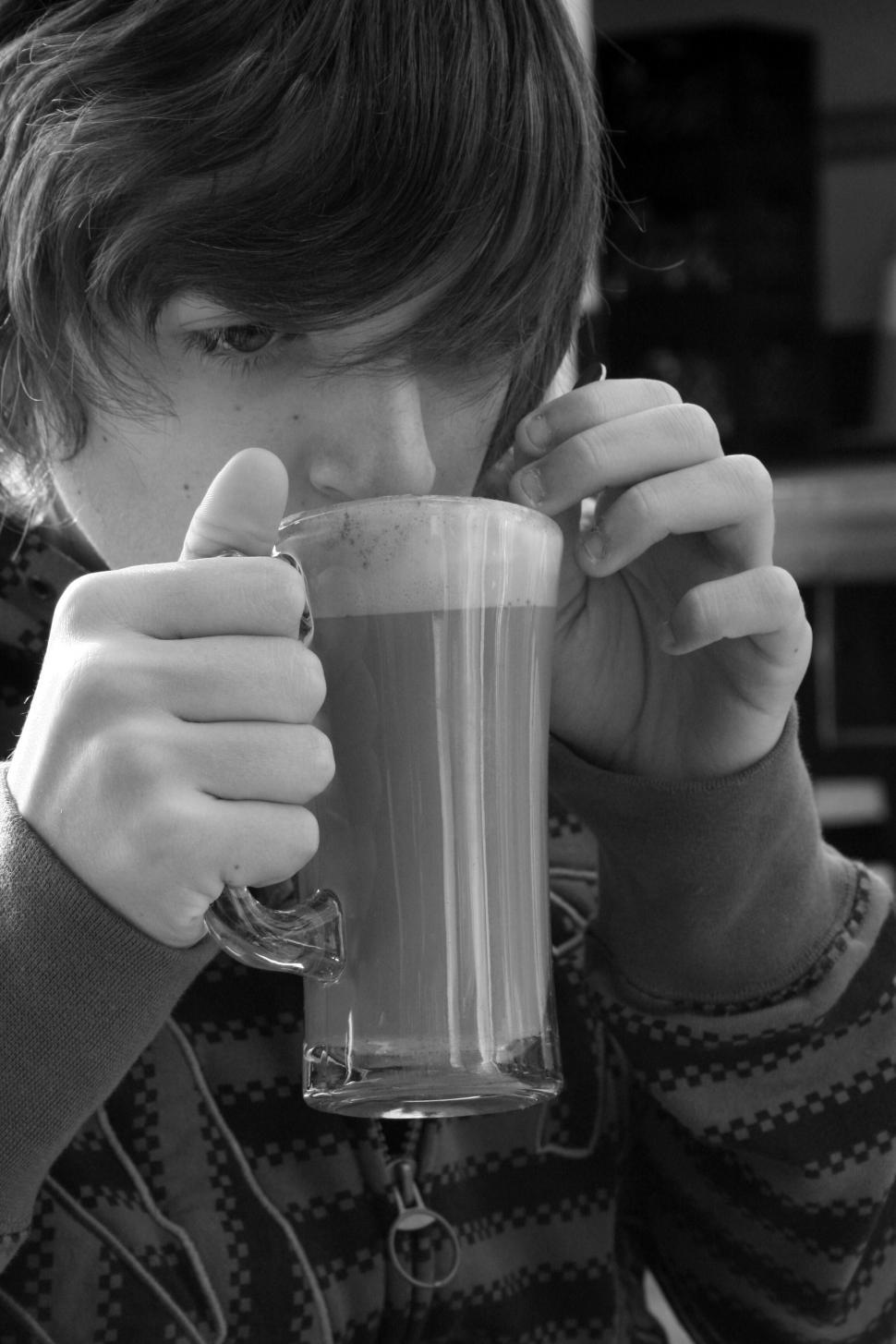 Free Image of Young boy drinking from a glass mug 