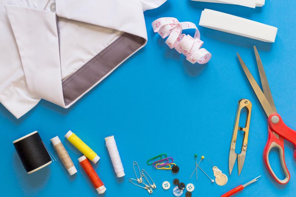 Free Image of Tailoring tools neatly arranged on blue surface 