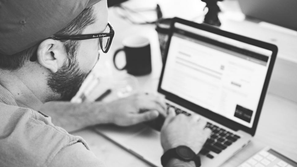 Free Image of Man working on laptop in grayscale 