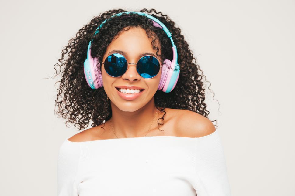 Free Image of A woman wearing headphones and smiling 