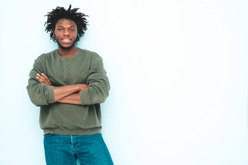 Free Image of A man with dreadlocks standing with arms crossed 