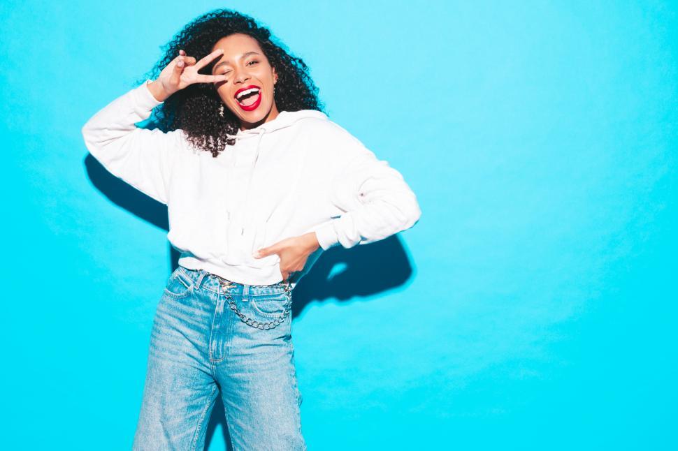 Free Image of A woman smiling and holding up two fingers 