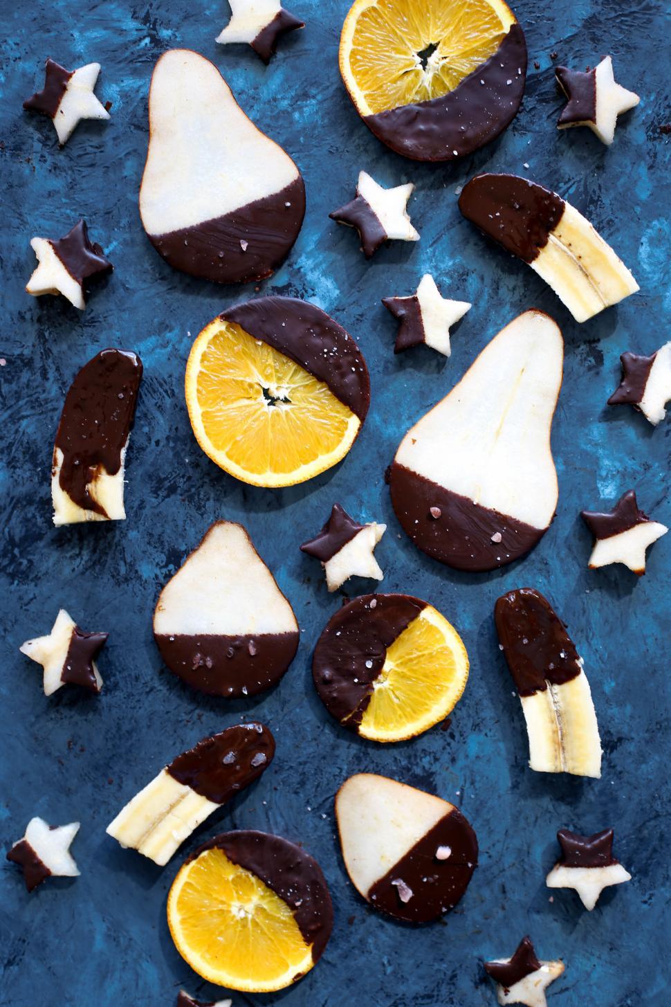 Free Image of Assorted chocolate dipped fruits on dark surface 