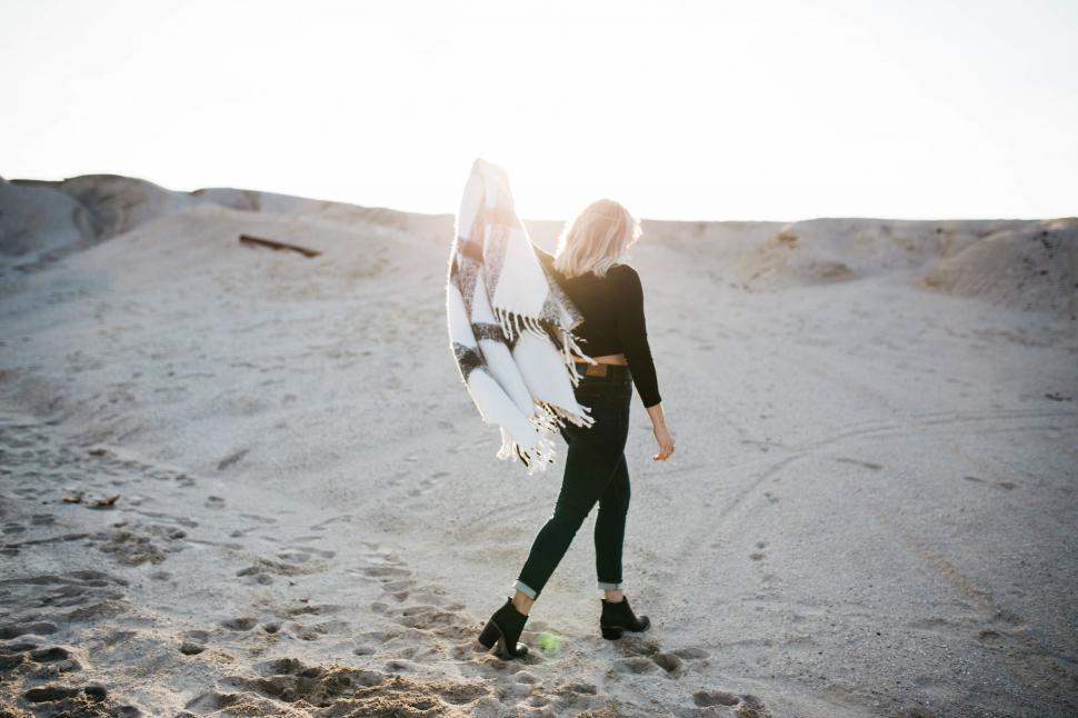 Free Image of Woman walking on beach at sunset 