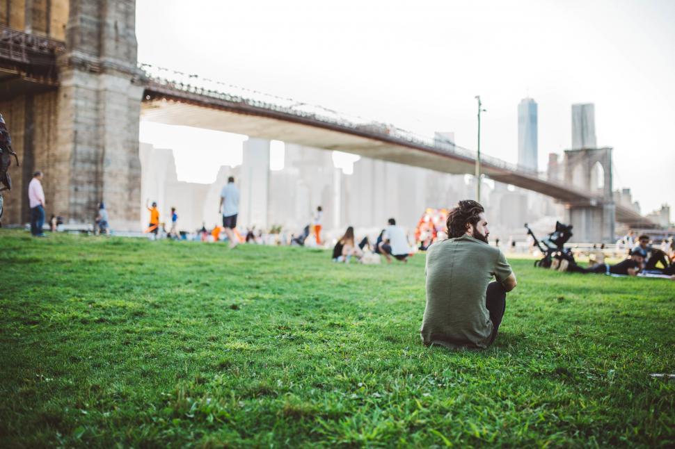 Free Image of Man sitting alone by the river in park 