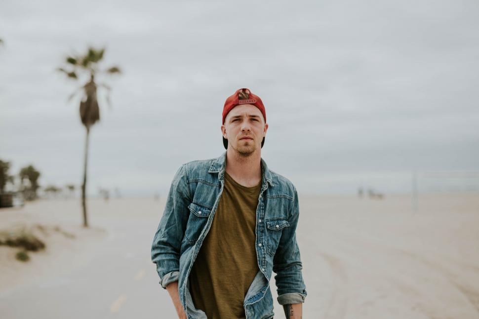 Free Image of Man in denim standing on beach path 