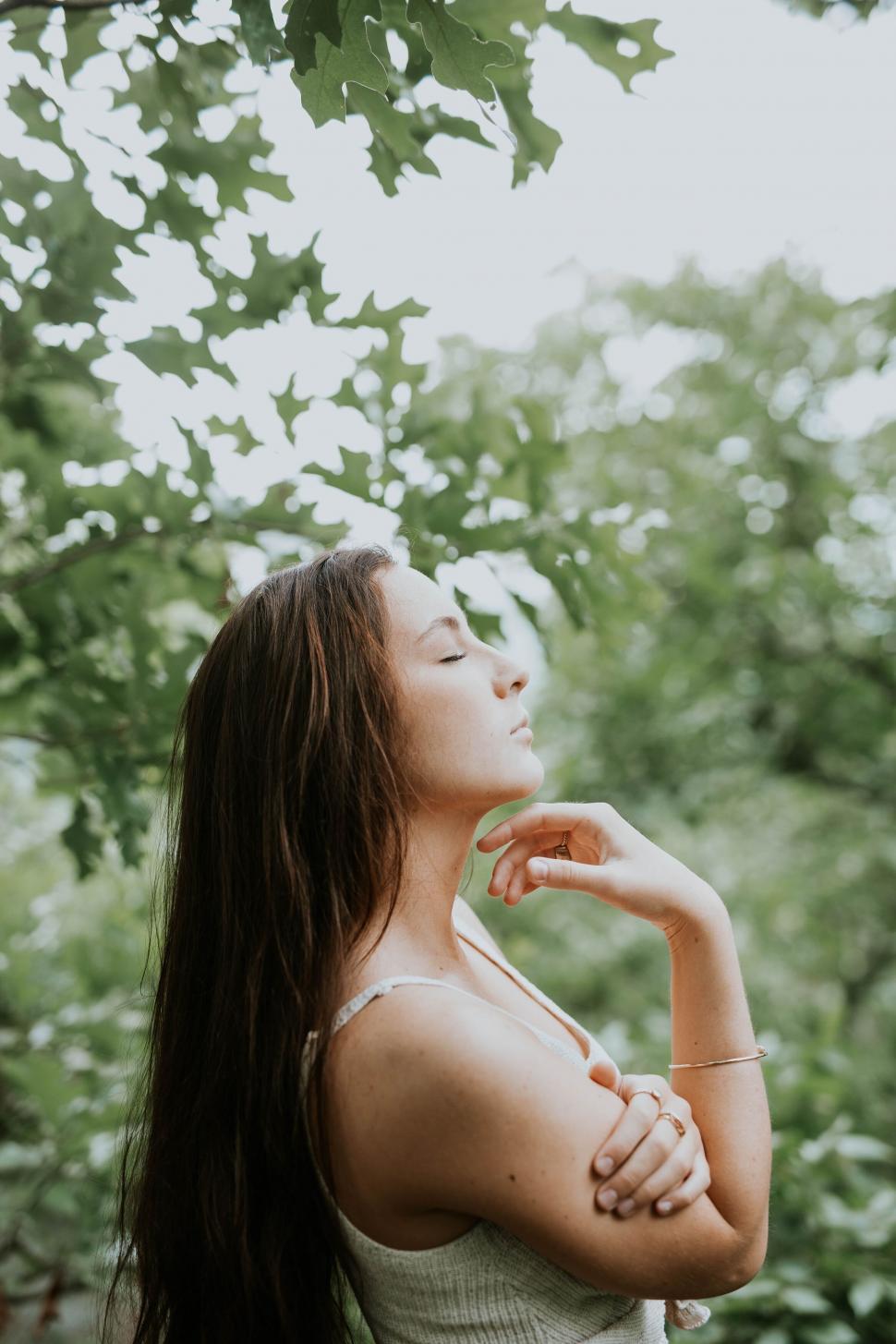 Free Image of Woman in nature holding her hair back 