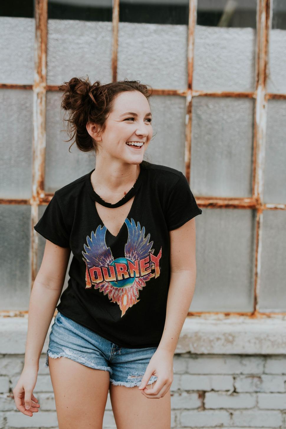Free Image of Woman laughing in front of vintage window 