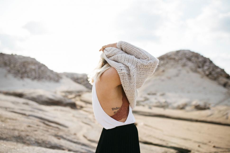 Free Image of Woman facing away in a sandy landscape 