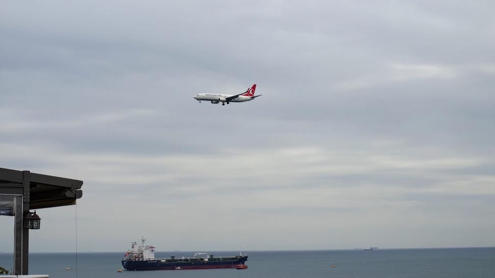 Free Image of Airplane landing over a coastal cityscape 