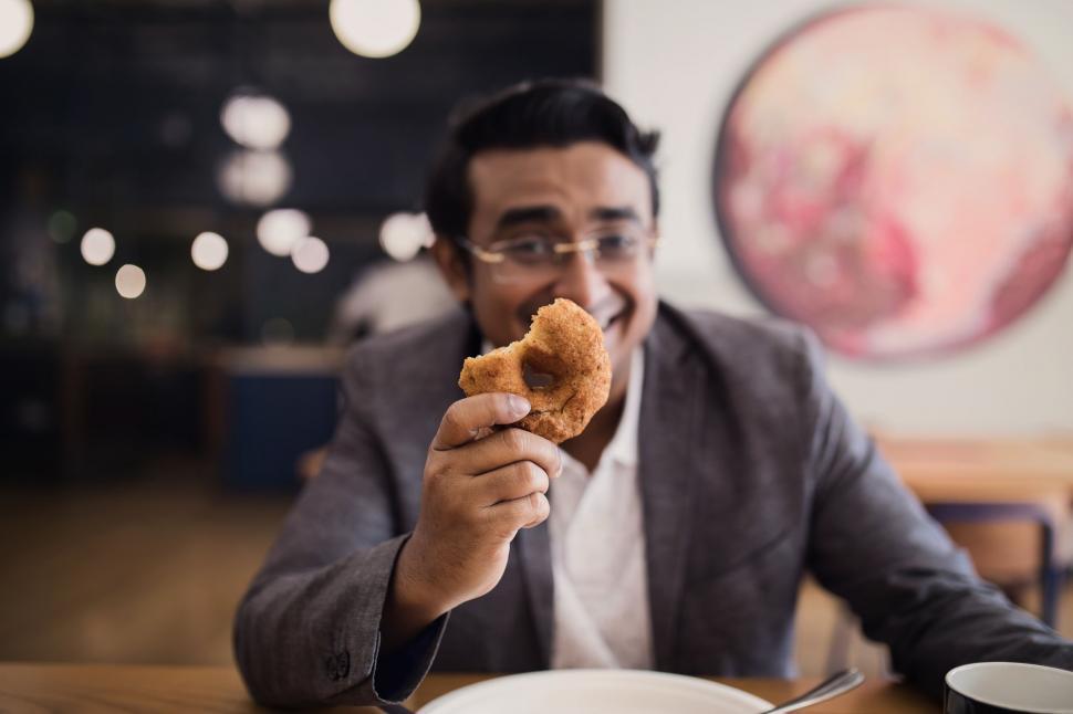 Free Image of Man eating at a contemporary restaurant 