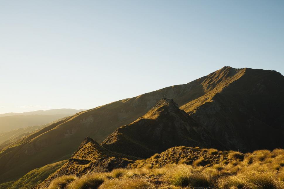 Free Image of Sunrise illuminating a rugged mountain ridge 