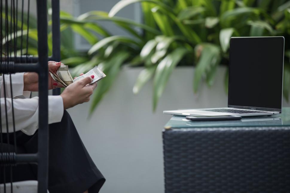 Free Image of Businessperson counting cash near laptop 