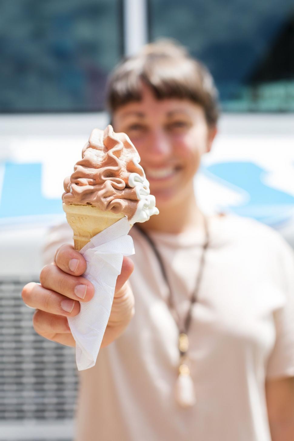 Free Image of Woman happily presenting an ice cream cone 