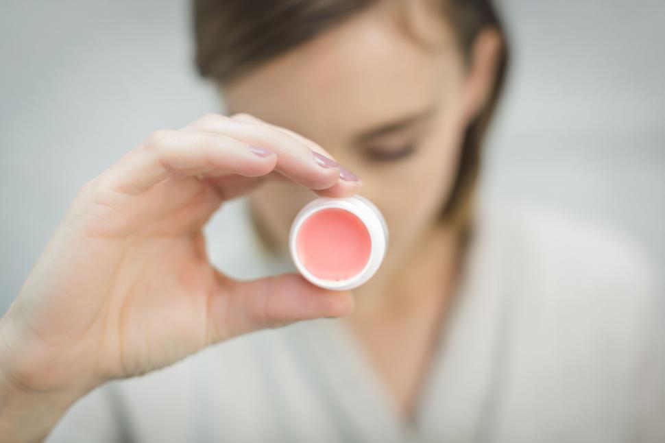 Free Image of Blurred face holding a square object in focus 