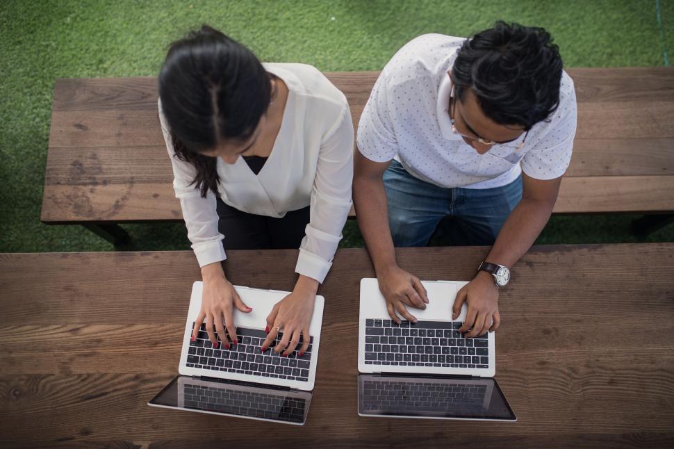 Free Image of Two professionals working on laptops aerial view 