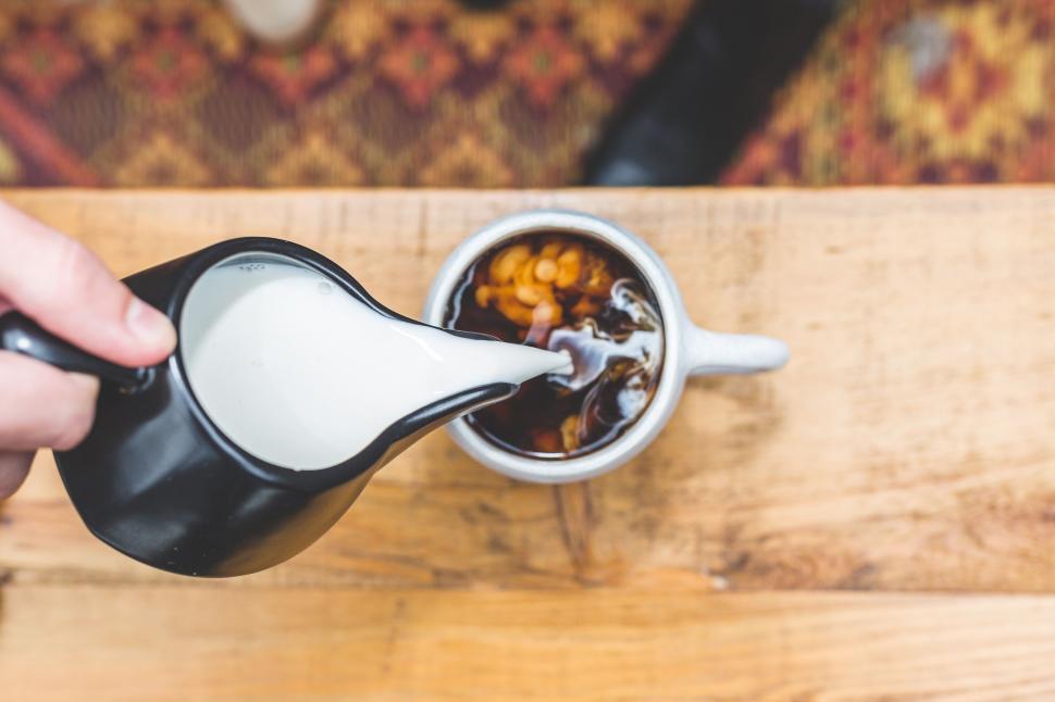 Free Image of Pouring milk into coffee cup 